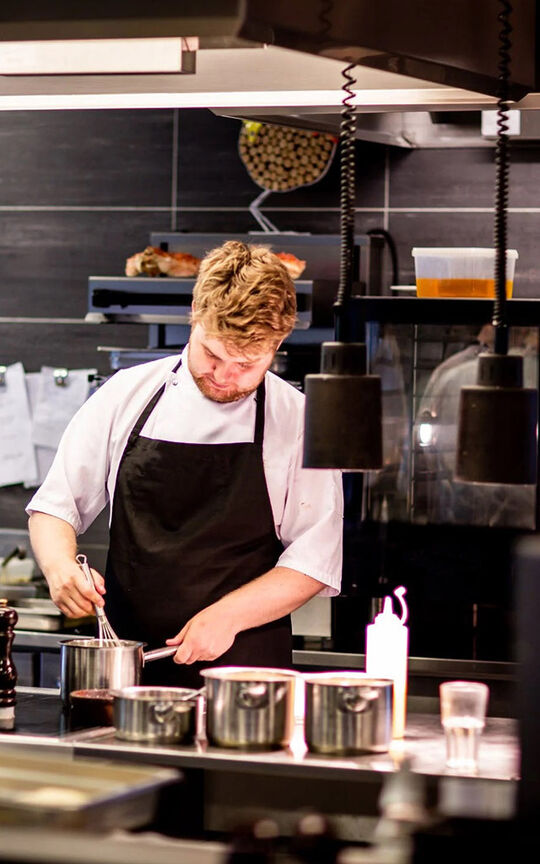Restaurateur préparant une assiette en cuisine